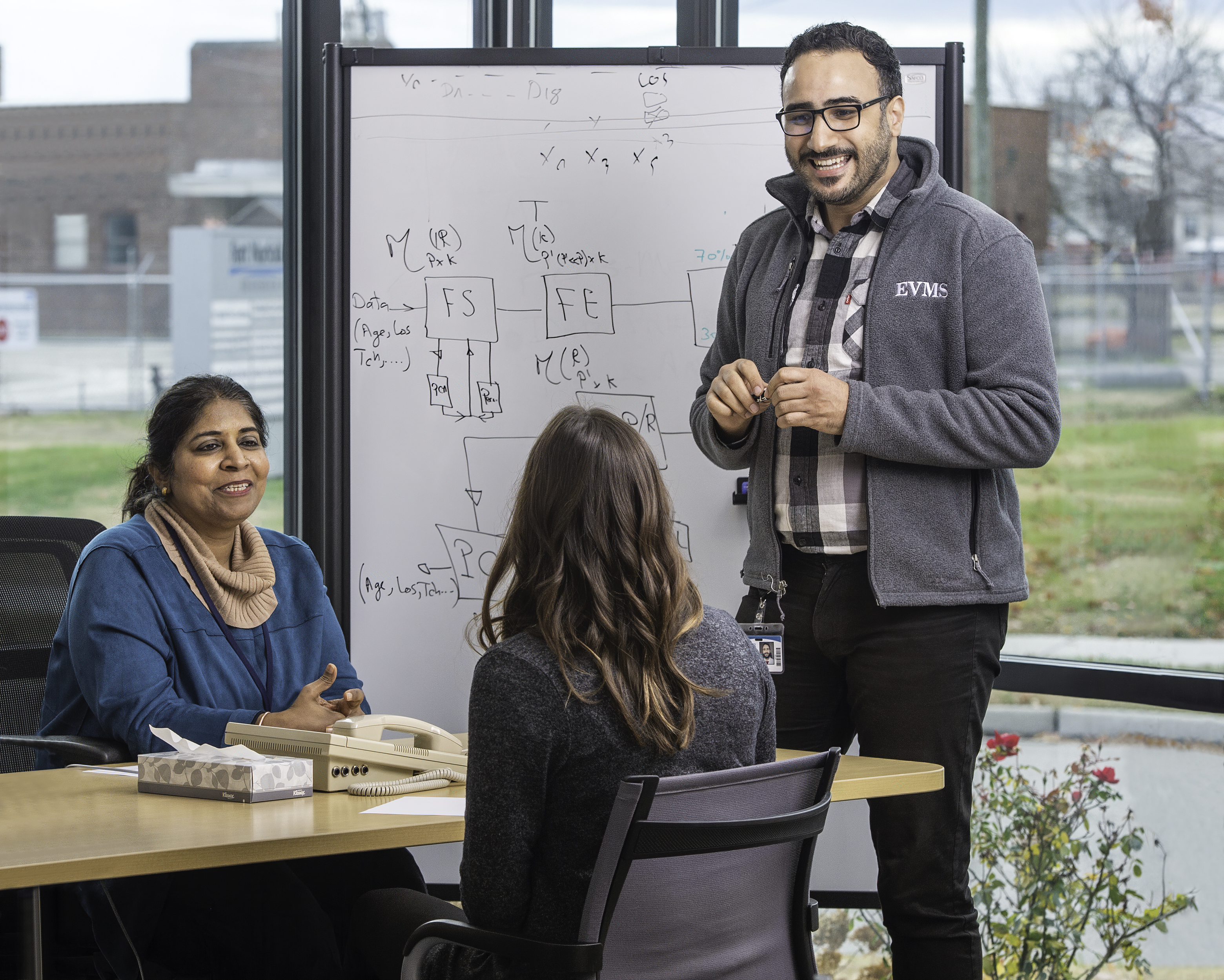 Sunta Dodani, M.D., Ph.D., left, meets with staff of the EVMS-Sentara Healthcare Analytics and Delivery Science Institute (HADSI)