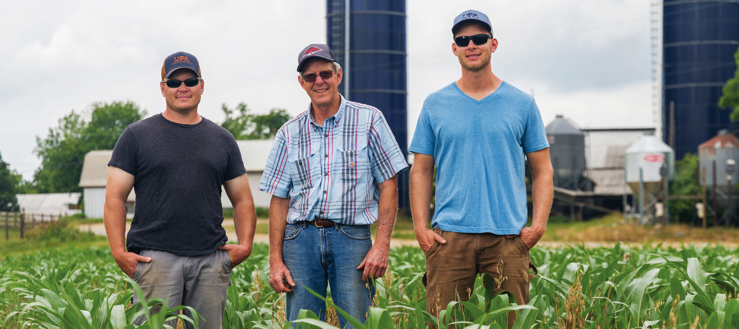 Three men stand in a field on Oakmulgee Dairy Farm in Amelia County, Virginia.