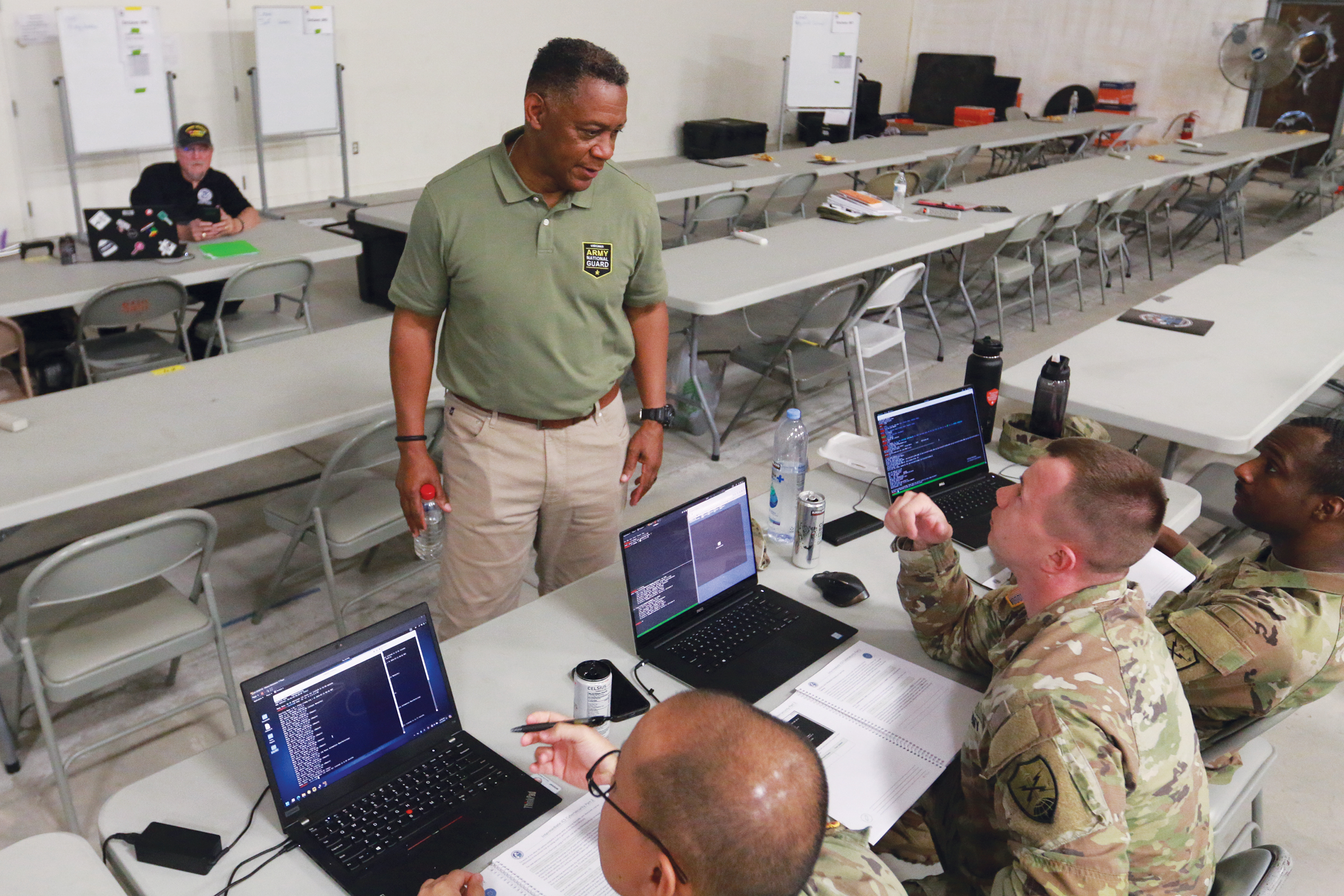 A National Guard Cyber Fortress instructor teaching 3 National Guard students