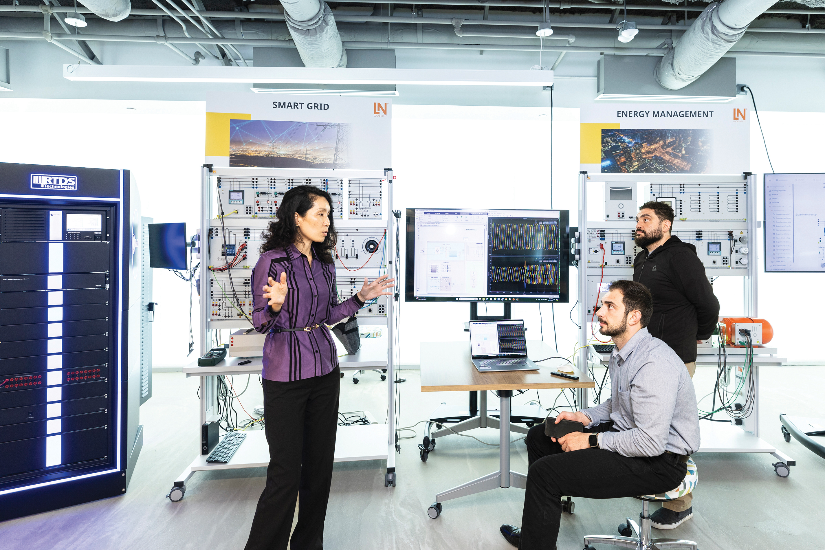 Three people in the Smart Grid lab at George Mason University