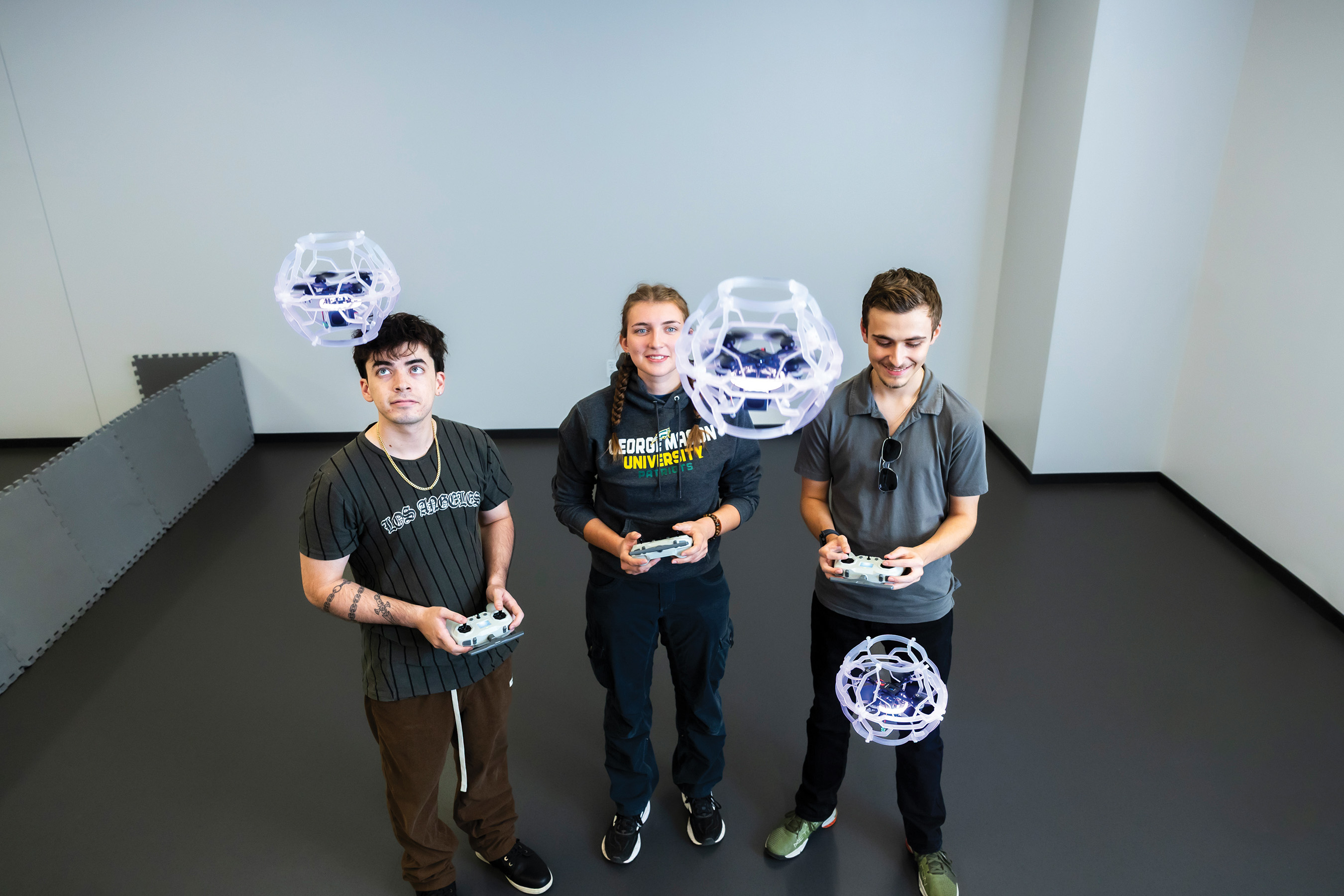 3 GMU students playing with drones 