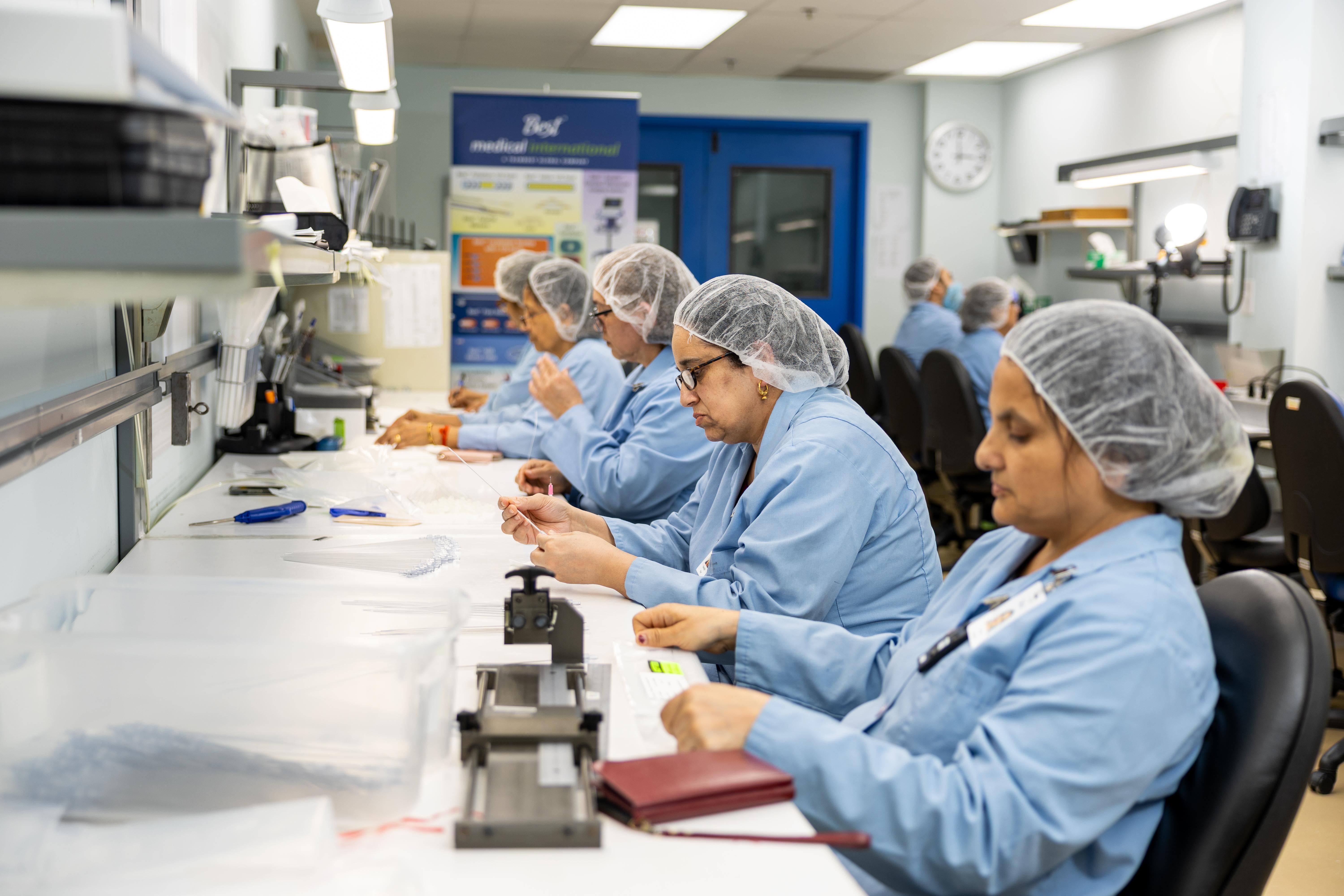 Row of employees working on a desk. 