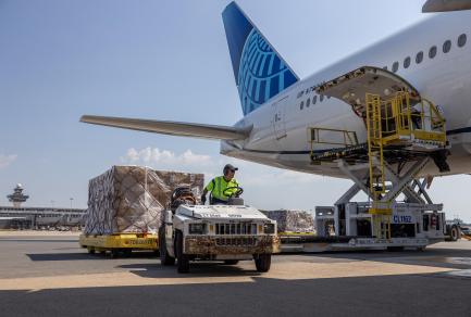 Airline worker transporting cargo at Washington Dulles International Airport. 