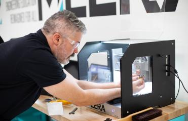 Man opperates 3D printer