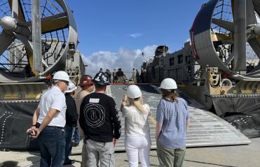 men and women looking at two boats