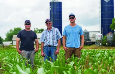 Three men standing in a field at Oakmulgee Dairy Farm