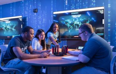 4 ODU School of Cybersecurity Students sitting around a table