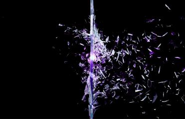 A black image of purple glass shattering 