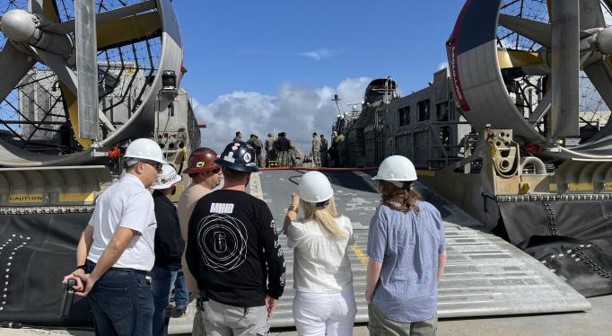 men and women looking at two boats