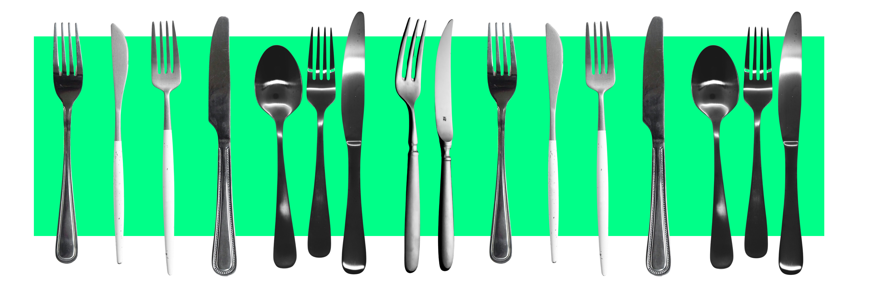 A row of forks, knives, and spoons are displayed in front a green bar