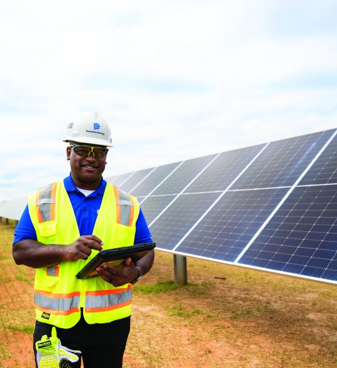 Dominion Energy employee in front of solar panels