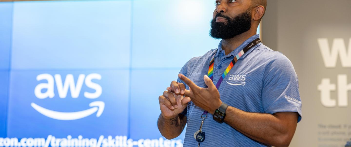 A man speaking in front of an Amazon Web Services screen