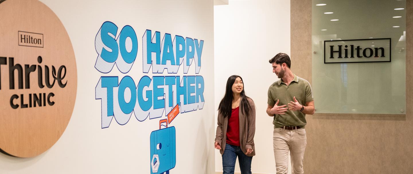 A man and a woman walking down a hallway