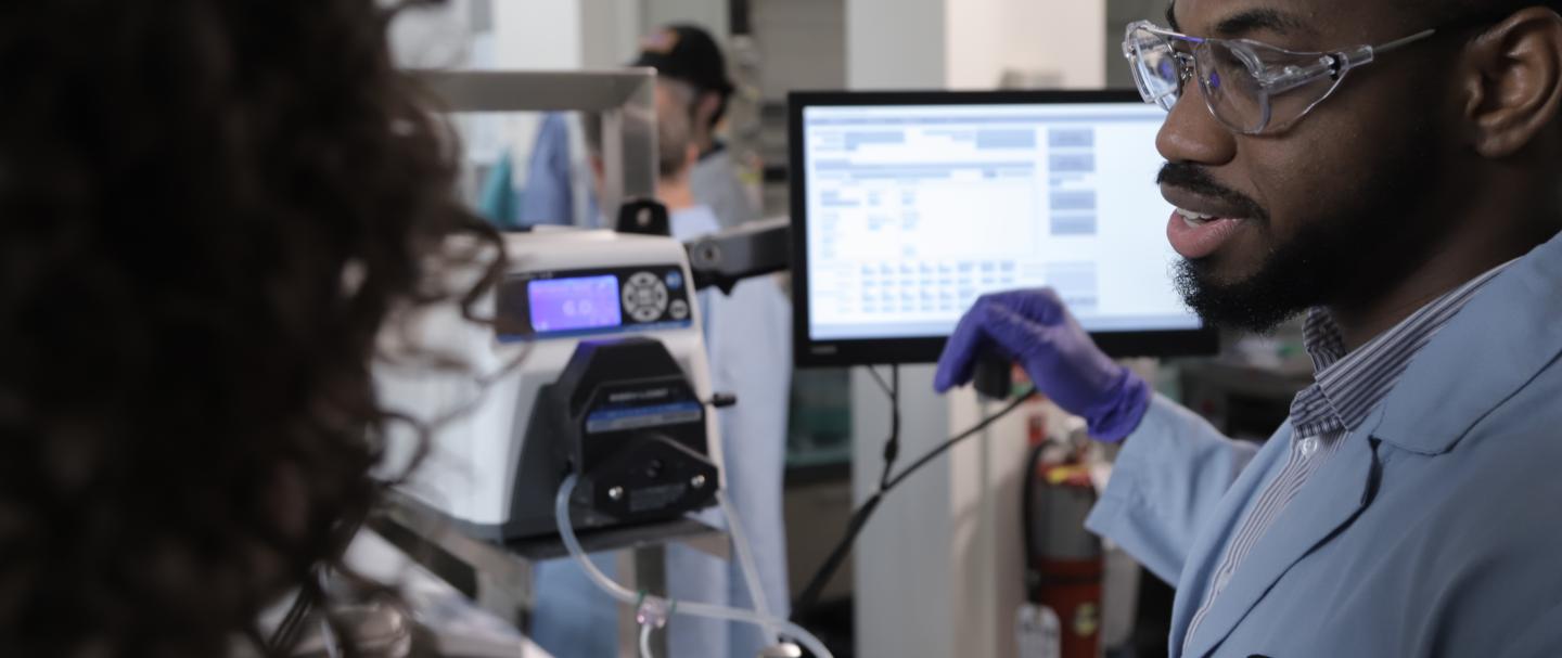 A man talks to a woman in front of medical monitoring devices