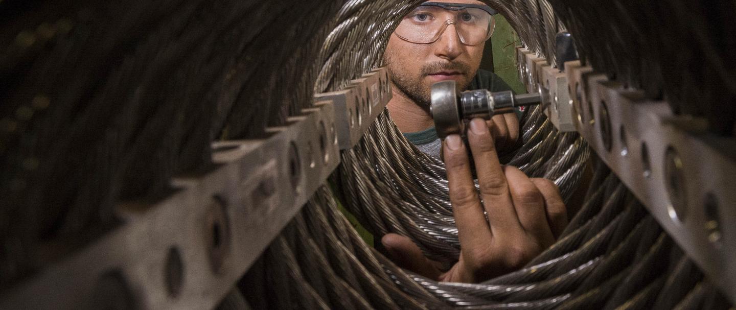 A man inserting a bolt into a connector