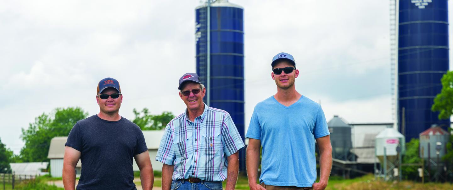 Three men standing in a field at Oakmulgee Dairy Farm