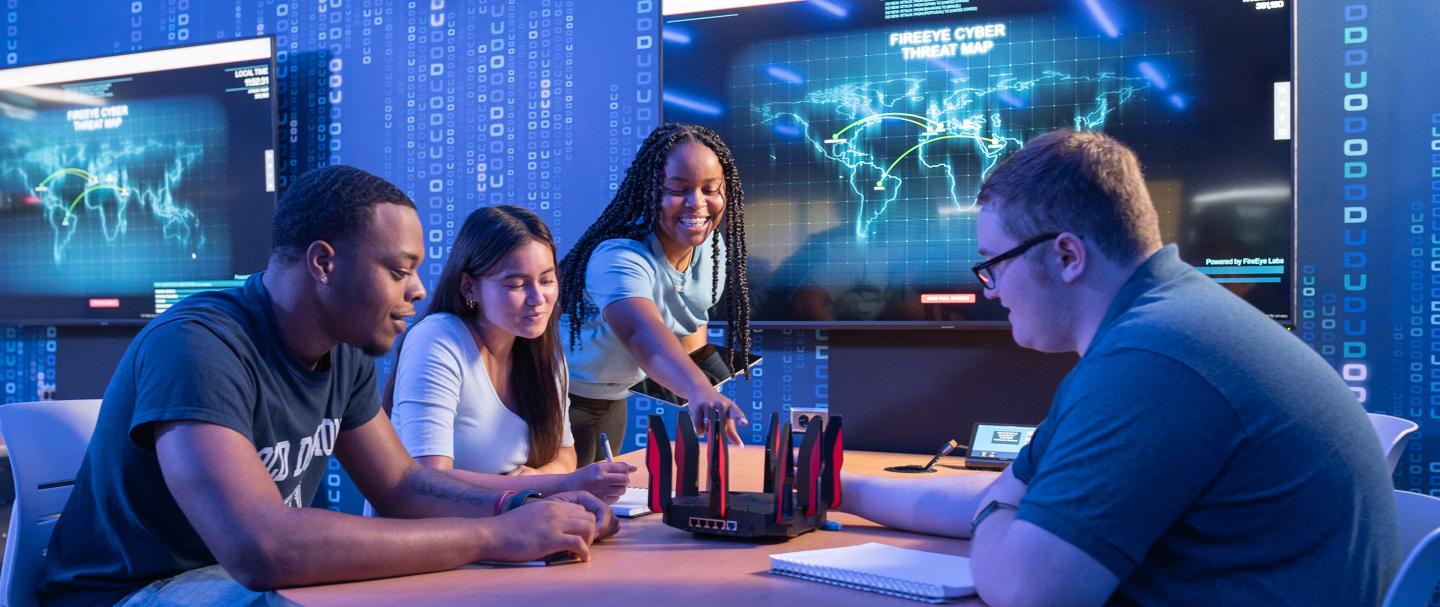 4 ODU School of Cybersecurity Students sitting around a table
