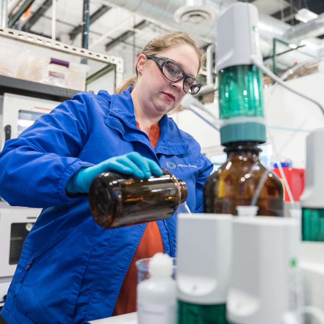 A woman working with chemicals in a lab