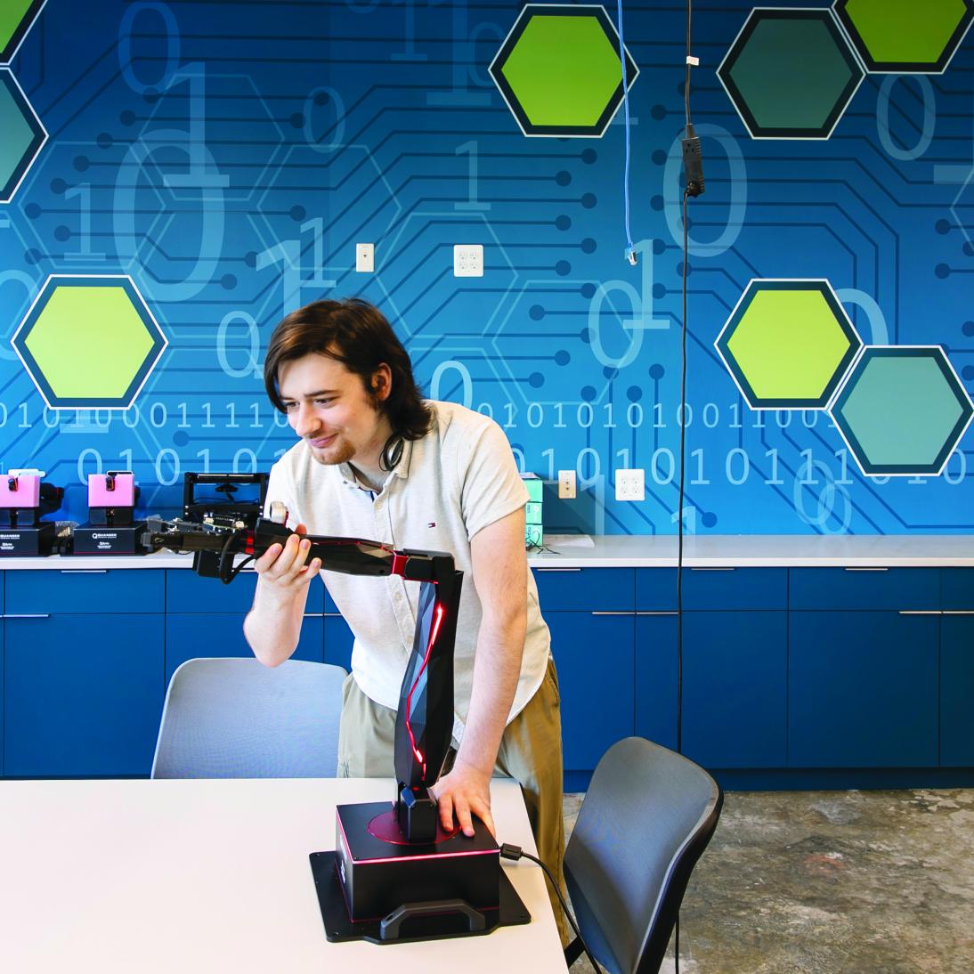 Young man working with a robotic arm
