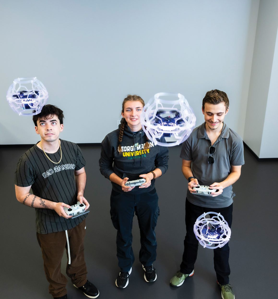 3 GMU students playing with drones 