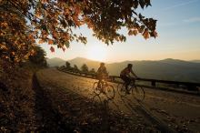 Two cyclists ride on a road in Virginia's Blue Ridge Mountains