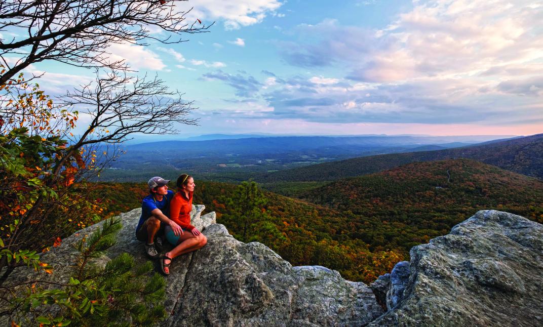 Photo of two hikers overlooking a mountain