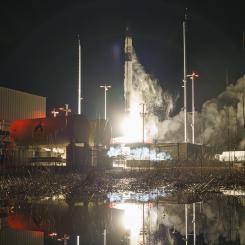 A rocket taking off from a launch pad at night