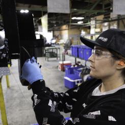 A woman working in a factory attaching a part to a trailer