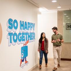 A man and a woman walking down a hallway