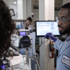 A man talks to a woman in front of medical monitoring devices