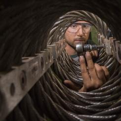 A man inserting a bolt into a connector