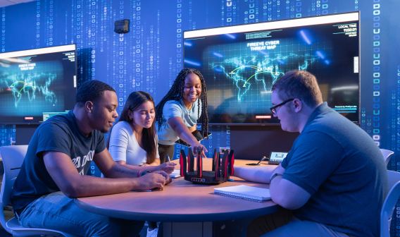 4 ODU School of Cybersecurity Students sitting around a table