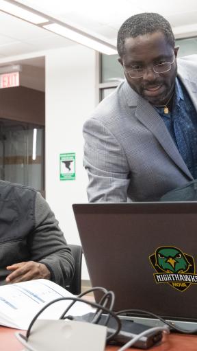 Three men looking at computers