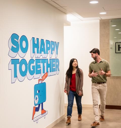 Two employees walking down a hallway