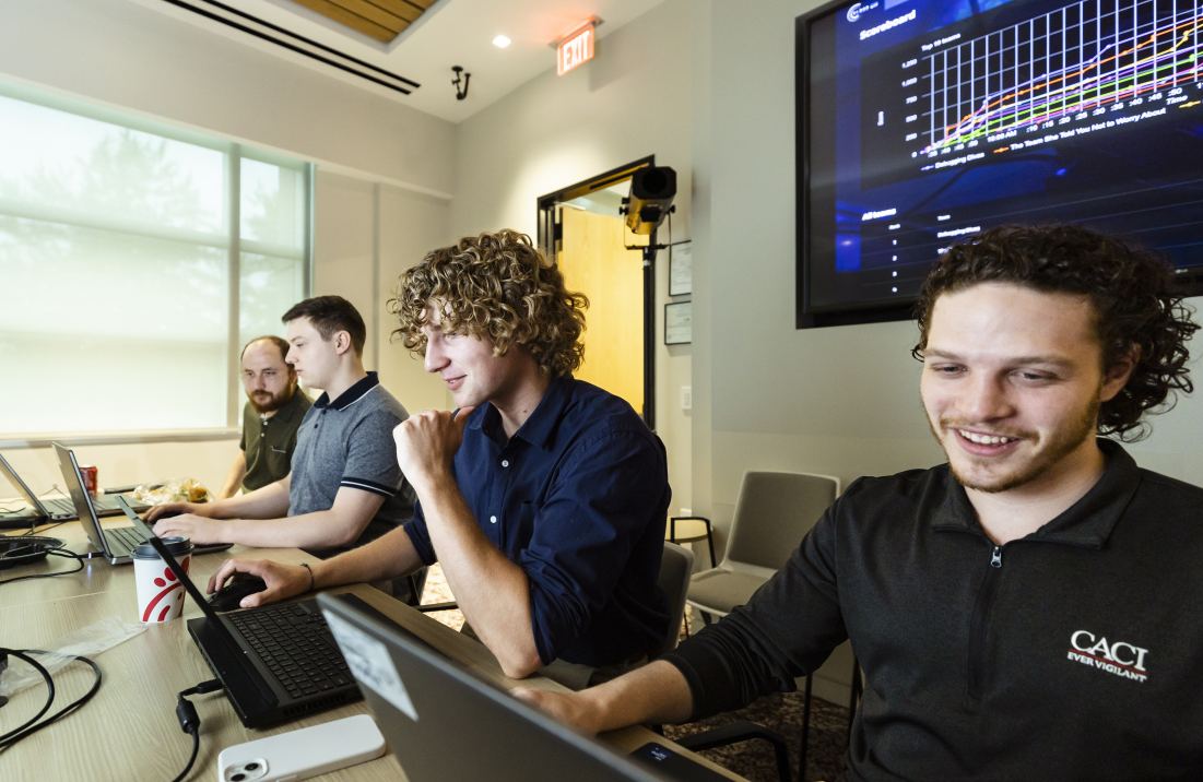 Three employees of CACI work on project-based learning initiatives. 