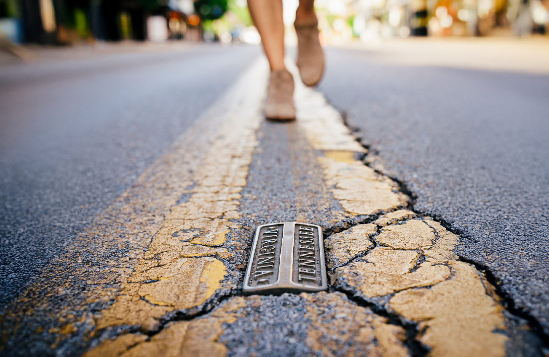 Person walking down the street, along the Virginia-Tennessee state line, in Bristol.