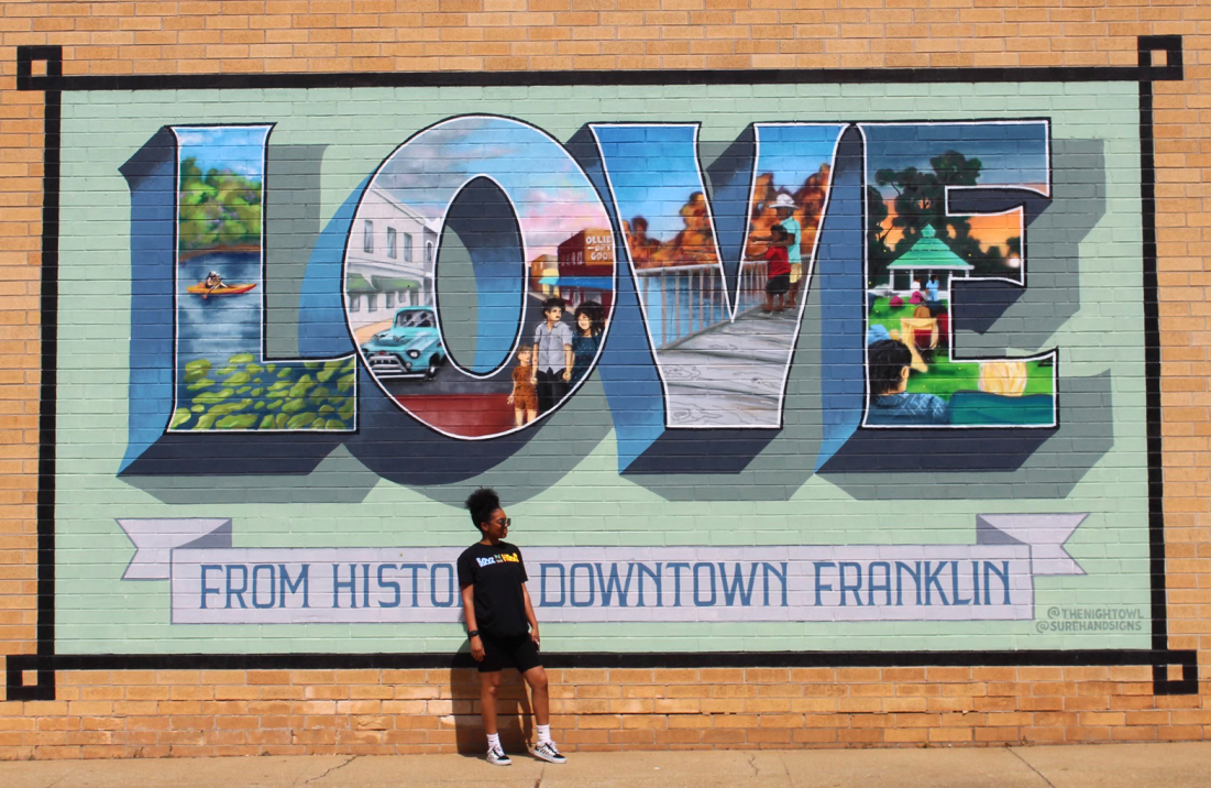 Woman in front of mural in downtown Franklin