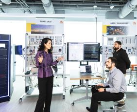 Three people in the Smart Grid lab at George Mason University